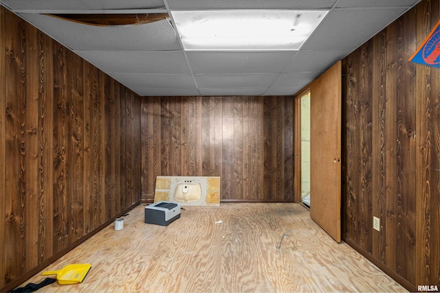 spare room with wood walls and a drop ceiling