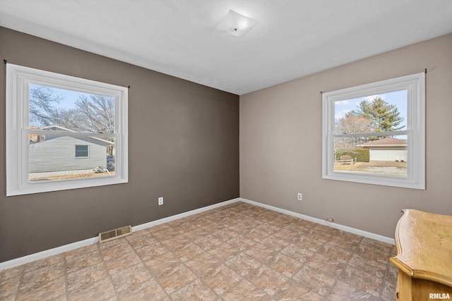 empty room with baseboards and visible vents