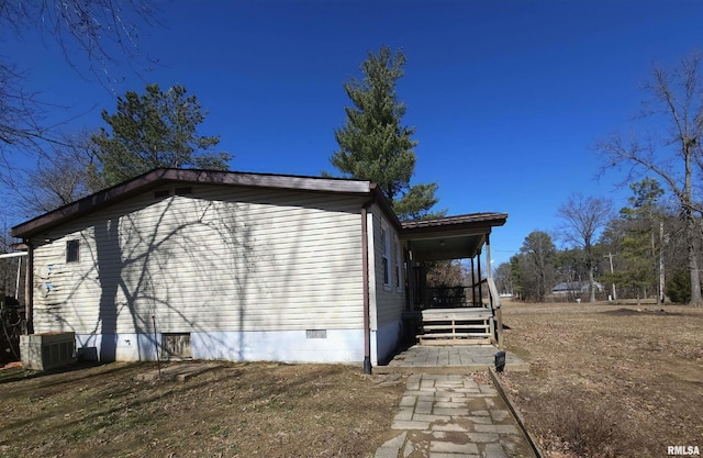 view of side of property with cooling unit and crawl space