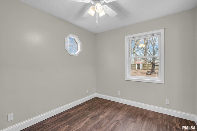 spare room with dark wood-style flooring, ceiling fan, and baseboards