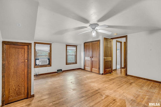 unfurnished bedroom with light wood finished floors, baseboards, vaulted ceiling, and cooling unit