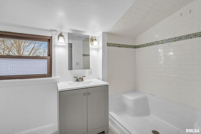 bathroom with  shower combination, lofted ceiling, and vanity