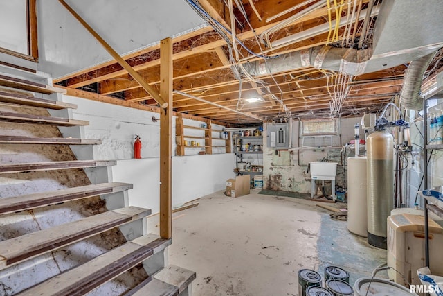 basement featuring electric panel, a sink, and stairway