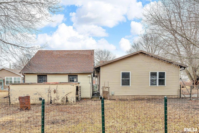 view of front of house with roof with shingles and fence