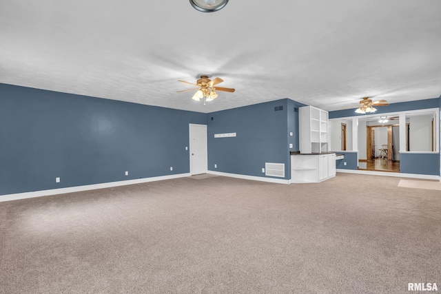 unfurnished living room featuring light carpet, ceiling fan, visible vents, and baseboards