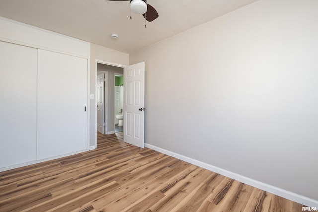 unfurnished bedroom featuring a closet, ceiling fan, baseboards, and wood finished floors