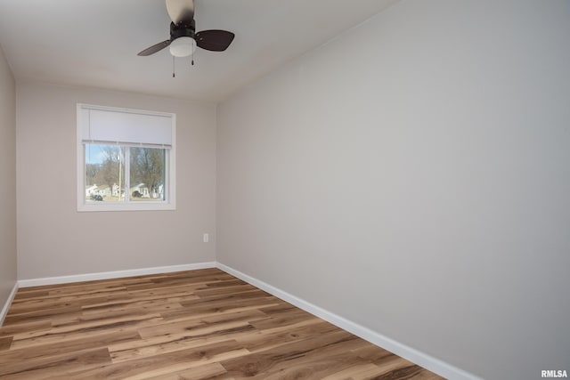 empty room with ceiling fan, baseboards, and wood finished floors