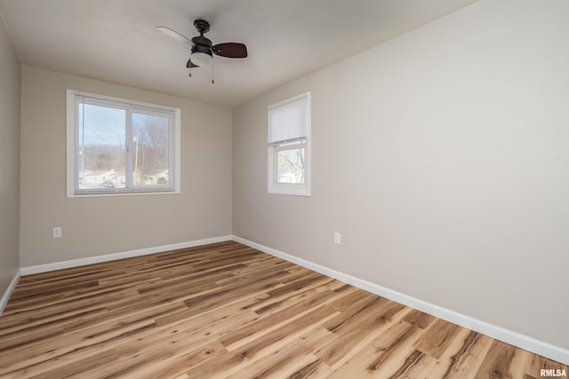 empty room featuring a ceiling fan, baseboards, and wood finished floors