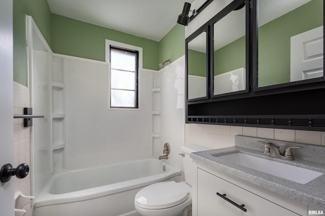 bathroom with tasteful backsplash, toilet, vanity, washtub / shower combination, and tile walls