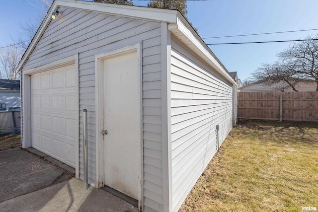 detached garage featuring fence