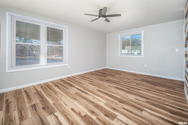 spare room with light wood-style floors, ceiling fan, and baseboards