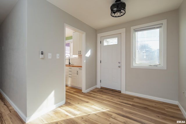 entrance foyer featuring plenty of natural light, light wood-style flooring, and baseboards