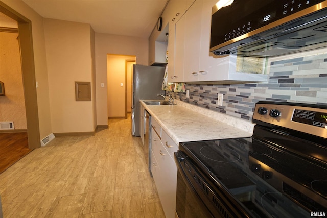 kitchen featuring a sink, visible vents, white cabinetry, appliances with stainless steel finishes, and range hood