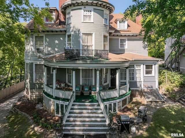 back of property featuring a balcony, stairway, fence, and a porch