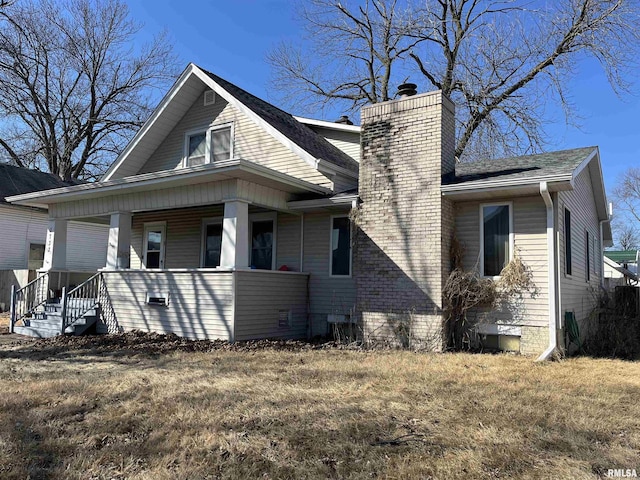 view of property exterior featuring covered porch and a chimney