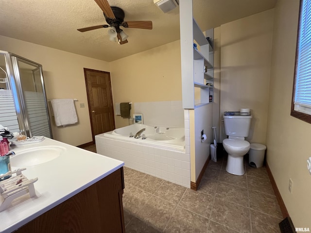 bathroom featuring a textured ceiling, ceiling fan, a garden tub, toilet, and vanity