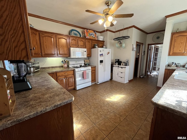 kitchen featuring white appliances, brown cabinetry, a ceiling fan, crown molding, and dark tile patterned floors