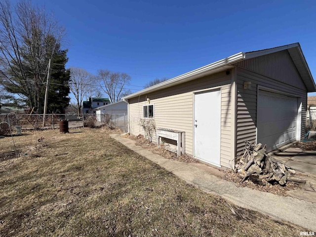 view of property exterior with a garage, an outdoor structure, and fence