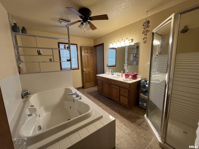 full bathroom featuring a shower stall, a tub with jets, a textured ceiling, and vanity