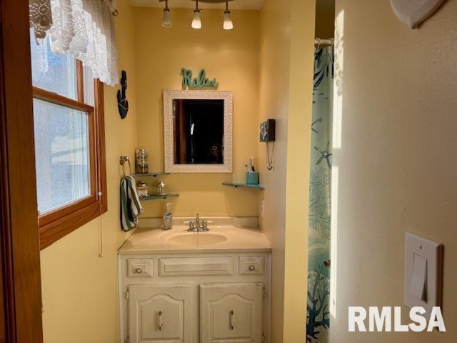 bathroom with a shower with shower curtain and vanity