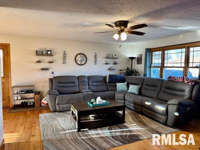 living area featuring ceiling fan, a textured ceiling, and wood finished floors