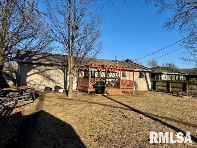 rear view of property with fence and a deck