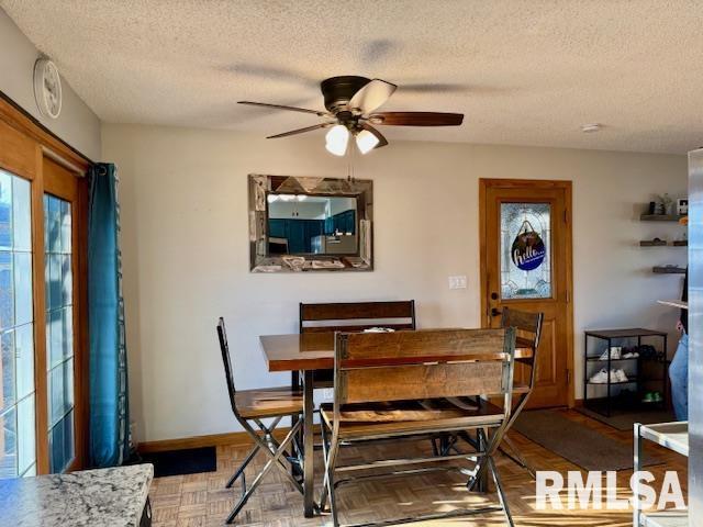 dining room with ceiling fan, a textured ceiling, and baseboards