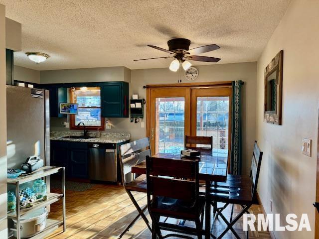 dining room featuring a ceiling fan, light wood-type flooring, french doors, and a textured ceiling