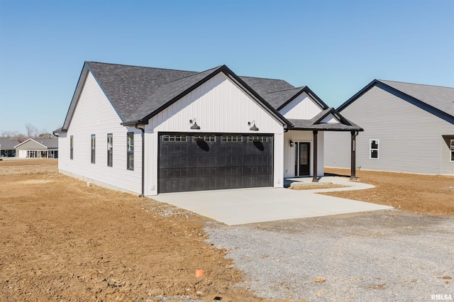 modern farmhouse style home featuring a shingled roof, driveway, and an attached garage