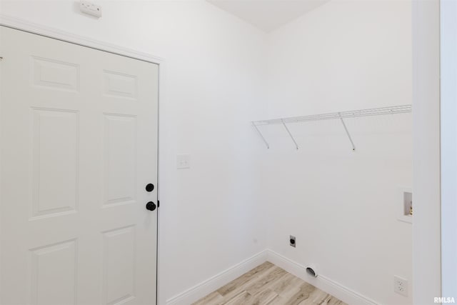 clothes washing area with washer hookup, light wood-style floors, hookup for an electric dryer, laundry area, and baseboards