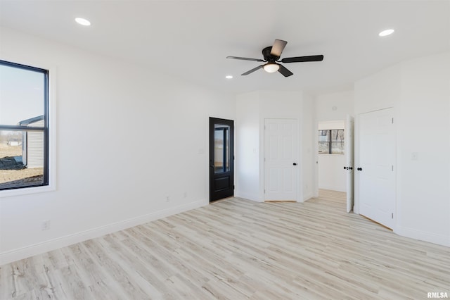 spare room with recessed lighting, a healthy amount of sunlight, and light wood finished floors