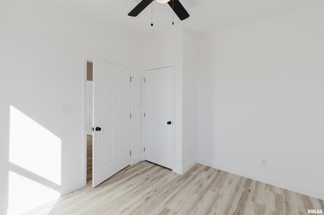 spare room featuring ceiling fan, wood finished floors, and baseboards