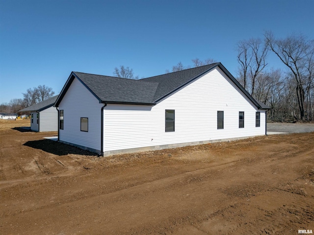 view of home's exterior with a shingled roof