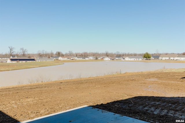 view of yard with a residential view and a water view