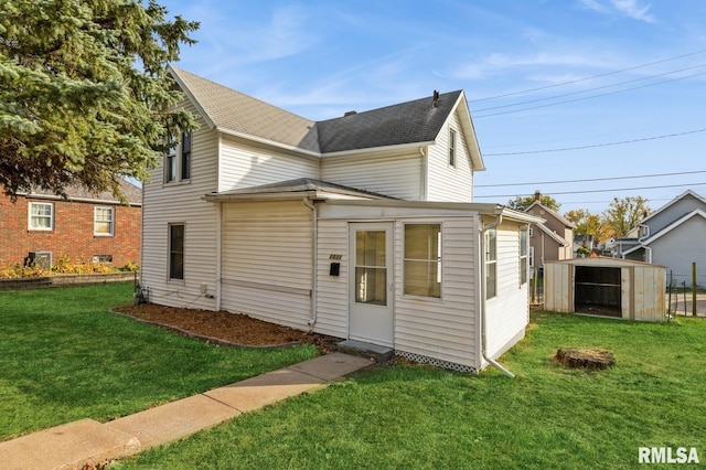 back of property with a lawn and roof with shingles