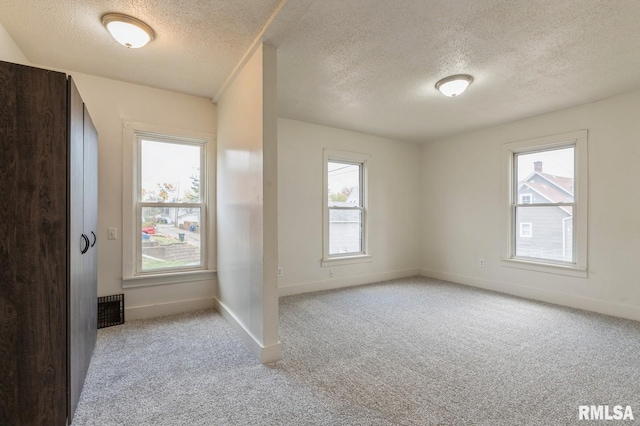 interior space with visible vents, a textured ceiling, and baseboards