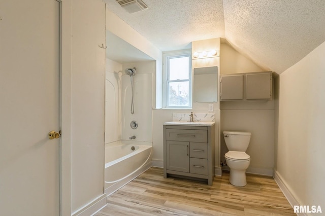 full bath featuring visible vents, toilet, vanity, wood finished floors, and a textured ceiling