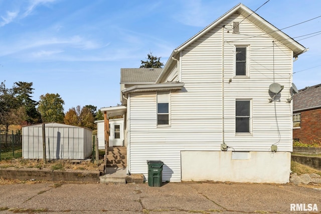 view of property exterior with an outdoor structure and a storage unit