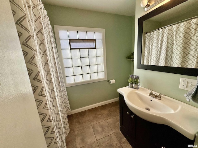 bathroom with vanity, tile patterned floors, and baseboards