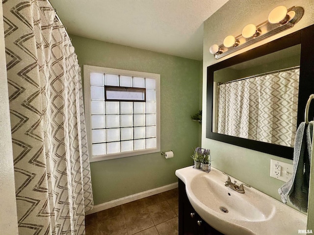 full bathroom featuring baseboards, a textured ceiling, vanity, and tile patterned flooring