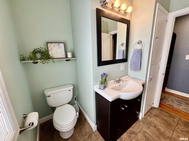 bathroom featuring tile patterned floors, baseboards, toilet, and vanity