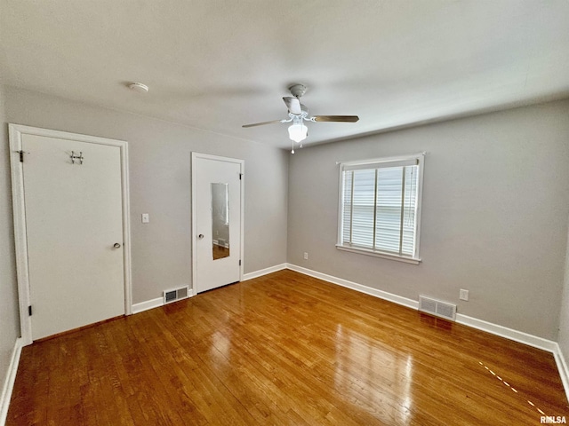 interior space with visible vents, ceiling fan, baseboards, and hardwood / wood-style floors