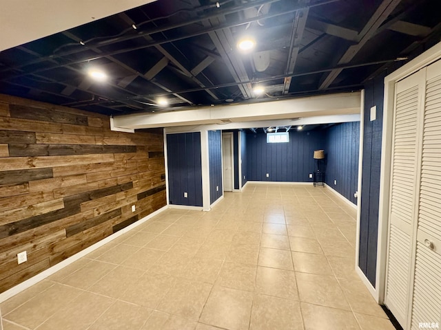 finished basement featuring wood walls and baseboards