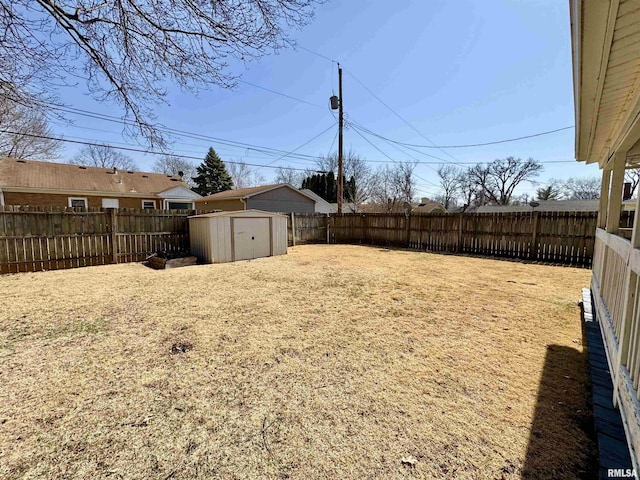 view of yard featuring a fenced backyard, a storage unit, and an outdoor structure