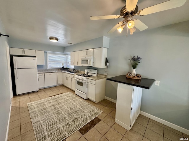 kitchen featuring white appliances, white cabinets, light tile patterned flooring, and baseboards