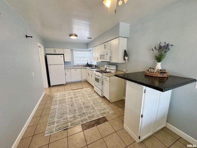 kitchen with light tile patterned floors, white cabinets, and white appliances