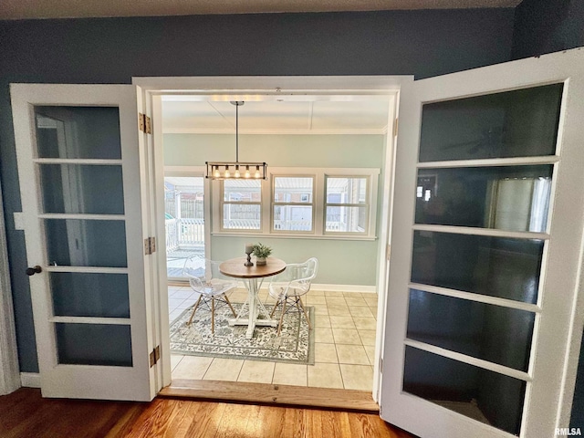 unfurnished dining area featuring wood finished floors, baseboards, and ornamental molding