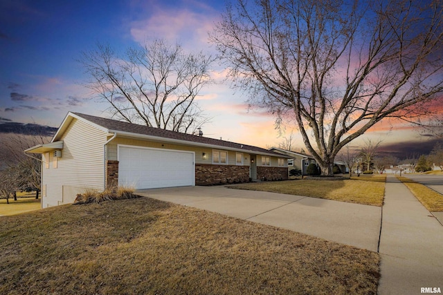 view of front facade featuring a garage, concrete driveway, and a front yard