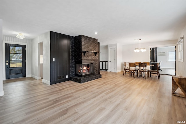 living room with a fireplace, baseboards, and light wood finished floors