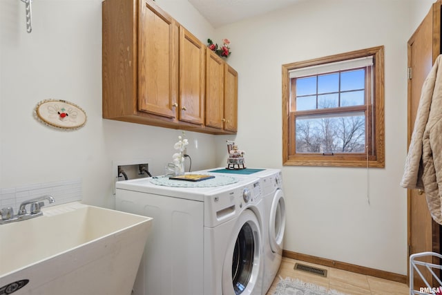 laundry room featuring visible vents, a sink, baseboards, cabinet space, and separate washer and dryer